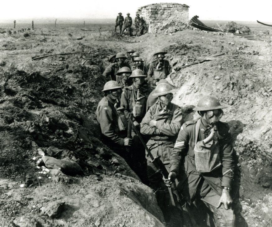 A row of soldiers wearing gas masks standing in a trench