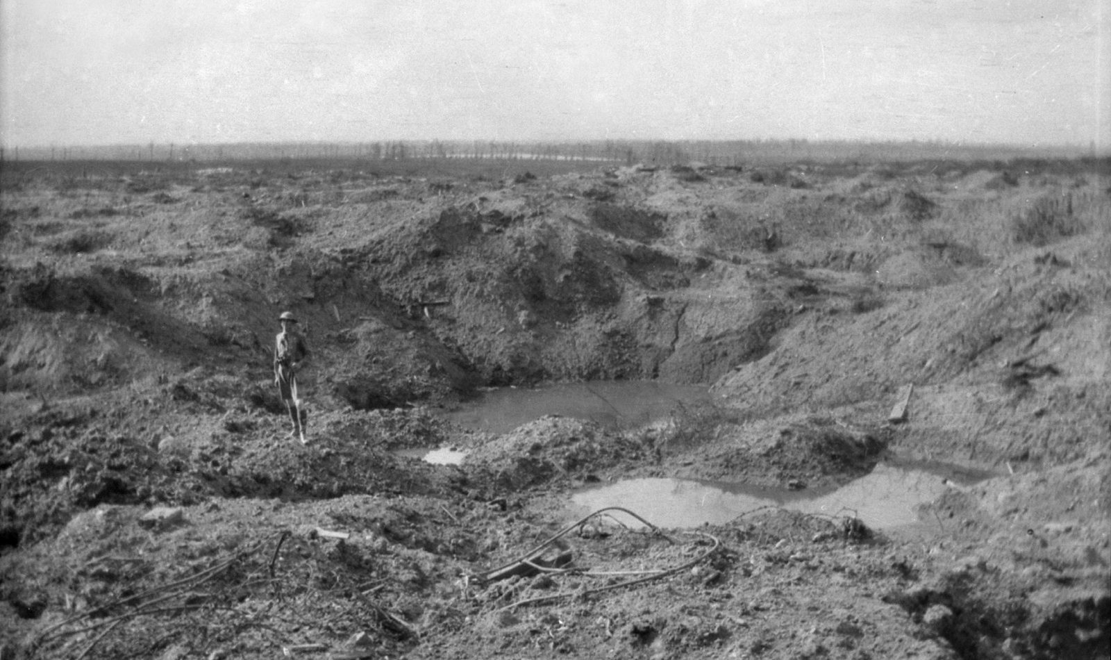 A soldier standing in a huge crater near Hill 60