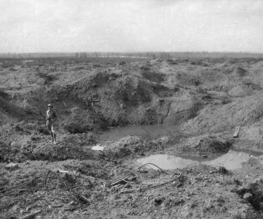 A soldier standing in a huge crater near Hill 60