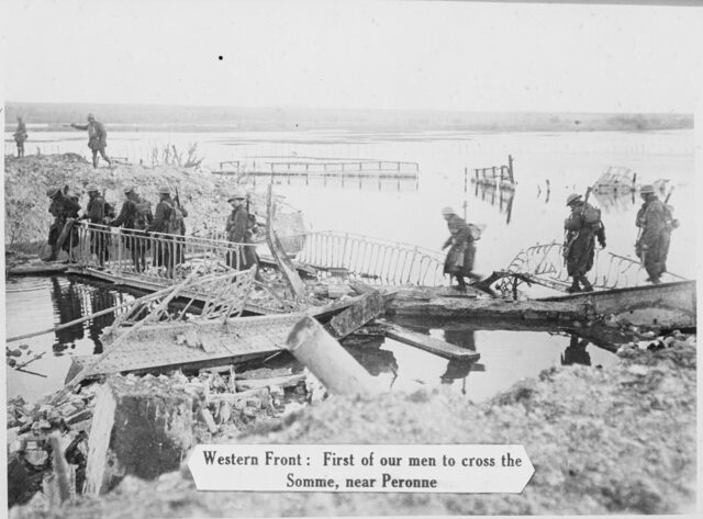 Les forces britanniques traversent un pont partiellement détruit sur la Somme, près de Péronne.