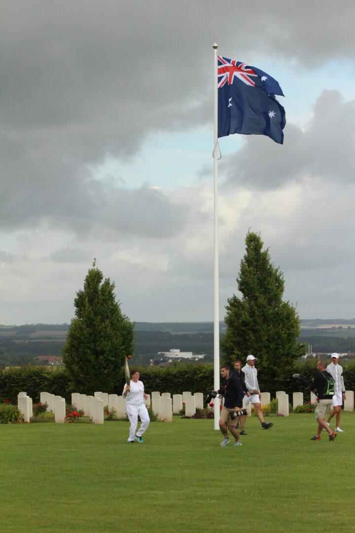 Floriane Bormans passing under the Australian flag at the Memorial site with the Olympic Torch.