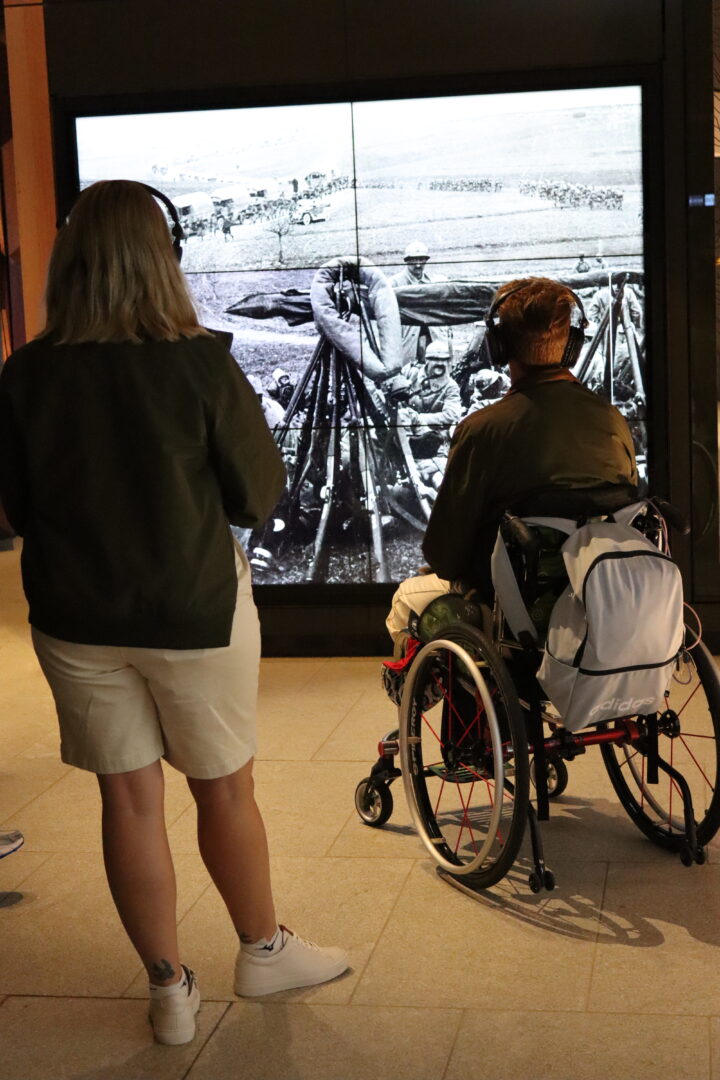 A visitor in a wheelchair watching a screen at the SJMC