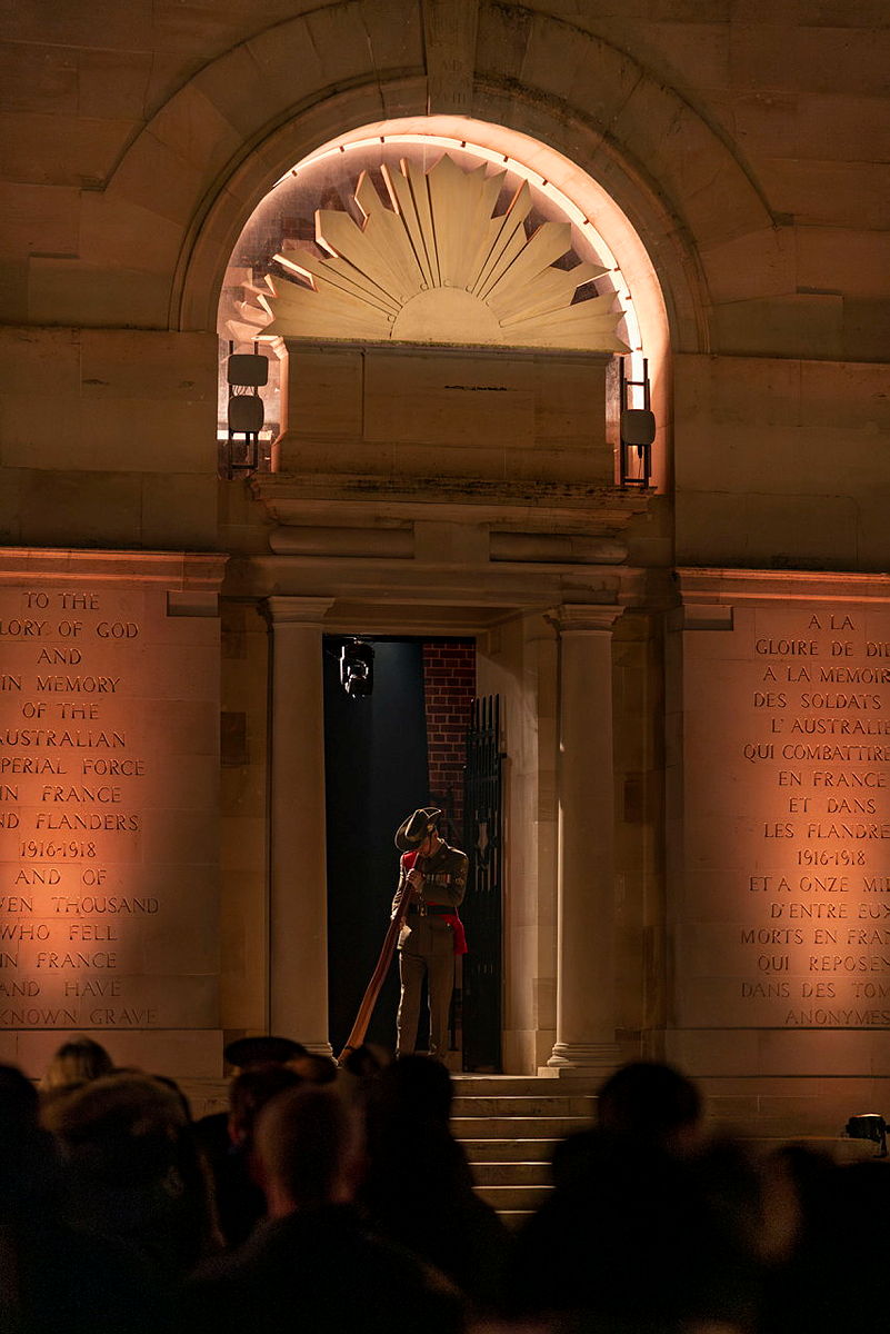 An Australian Army soldier playing the didgeridoo at the foot of the Australian National Memorial.
