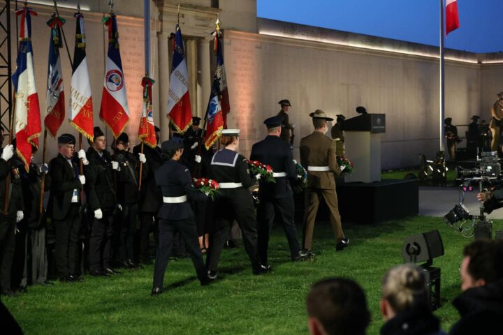 Four Australian Armed Forces wreath bearers walking towards the memorial.