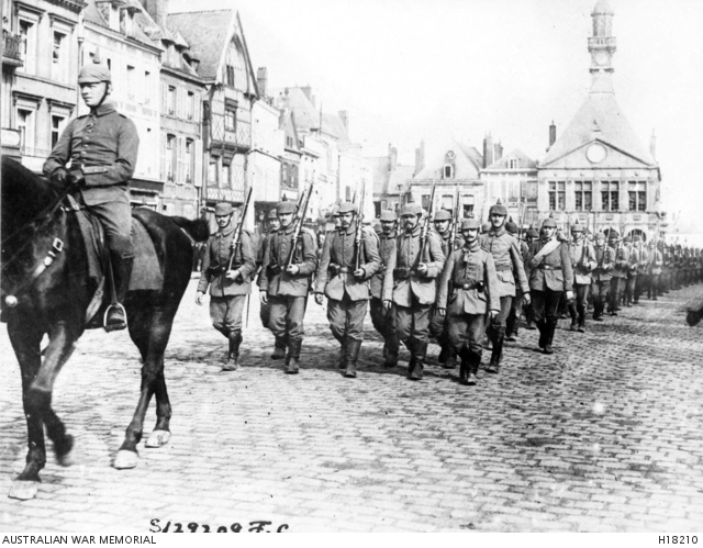 German Army troops marching through the town after having captured it.
