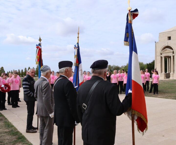 The flag bearers standing with their backs to the memorial