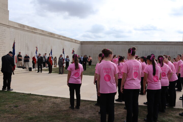 The choir members gathered in front of the memorial, with the flag bearers at the front.