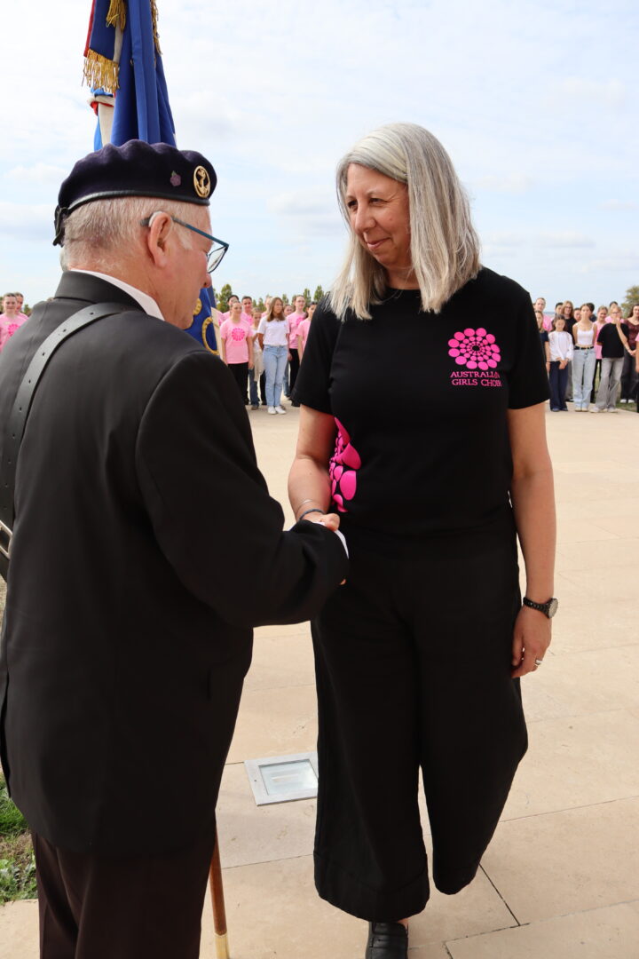 The choir director, Mrs Libby Franke greeting a flag-bearer